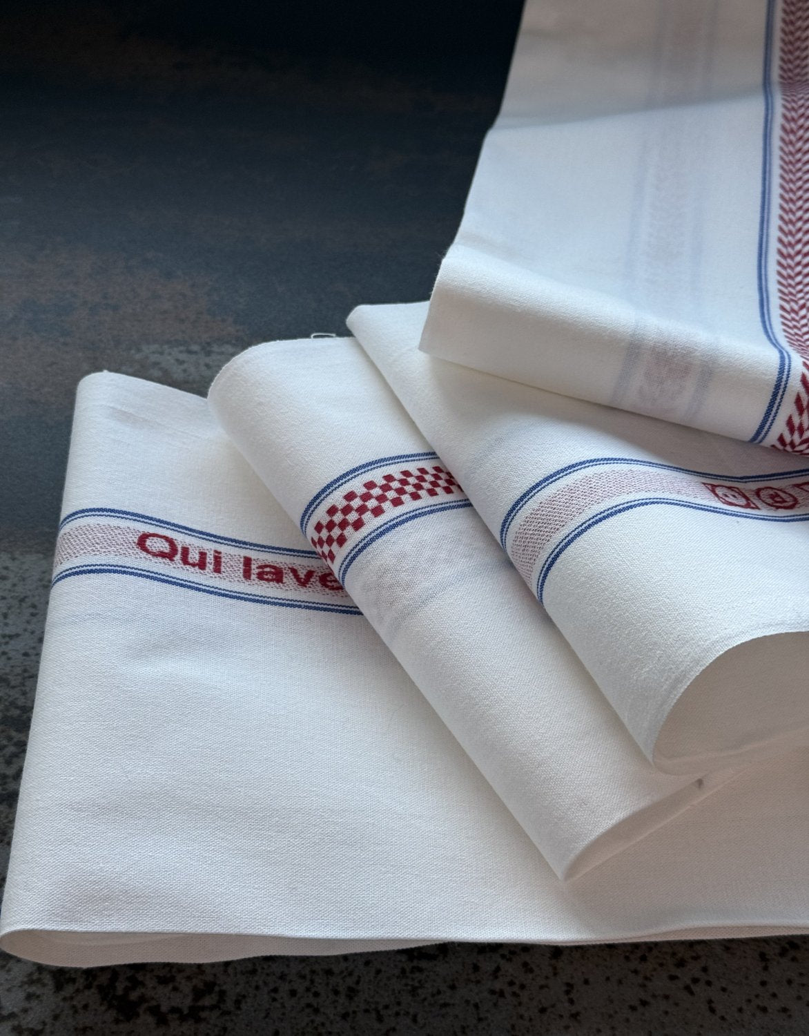 Charvet Editions "Qui Lave? J’Essuie!", white woven cotton tea towel. Made in France.